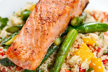 Wall Mural - Pan fried salmon with tender asparagus and courgette served on couscous mixed with sweet tomato, yellow pepper salsa.