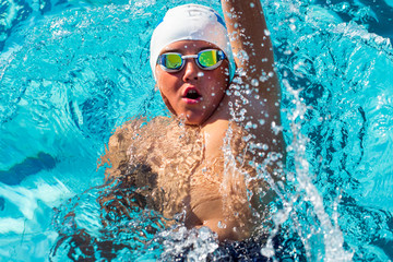 Action shot from top of boy swimming backstroke.