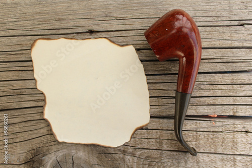 Fotografia Smoking pipe and empty paper for copy space - hipster fashion - on wooden backgr