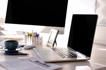 Workplace with computer and laptop on the table, close up