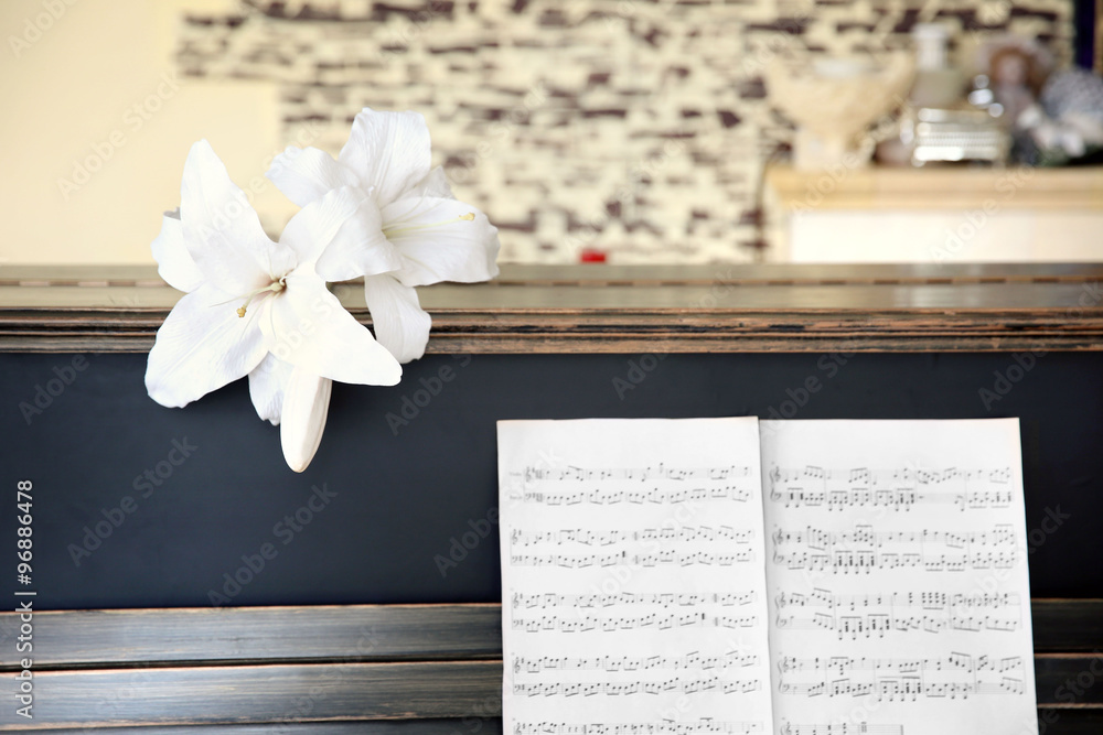 Vintage old classic piano with flower and musical notes, close up
