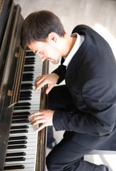 Poster - Handsome man in black suit plays piano in the class