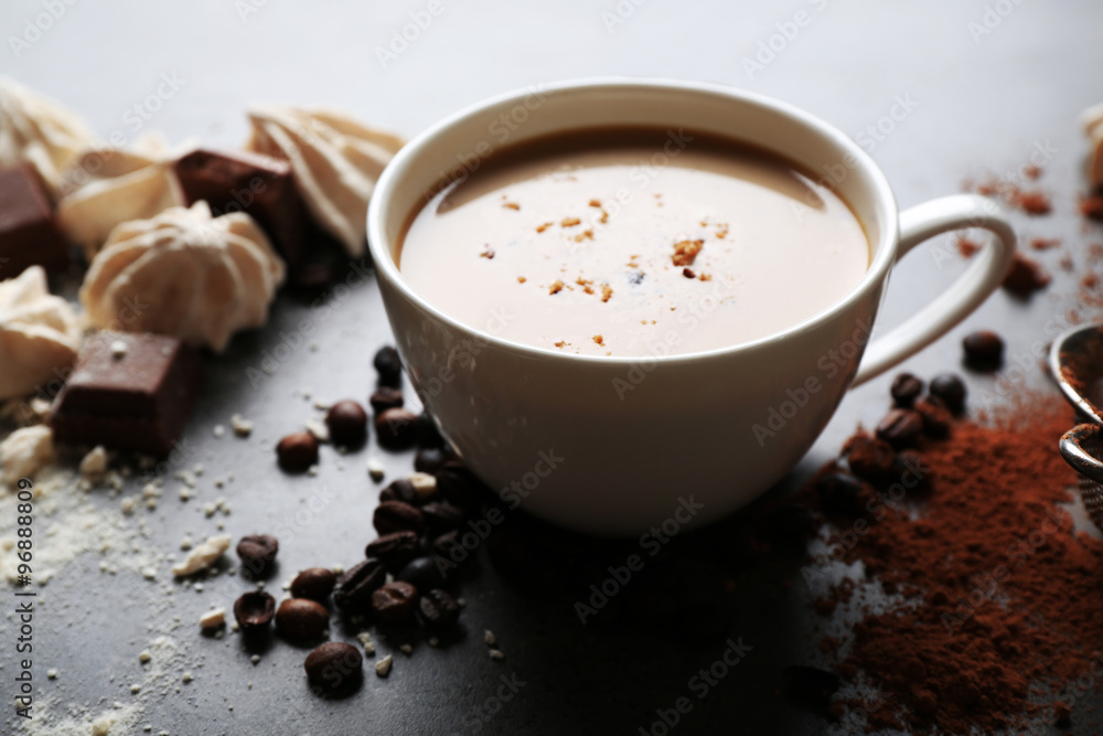Cup of coffee and sweets on black wooden background