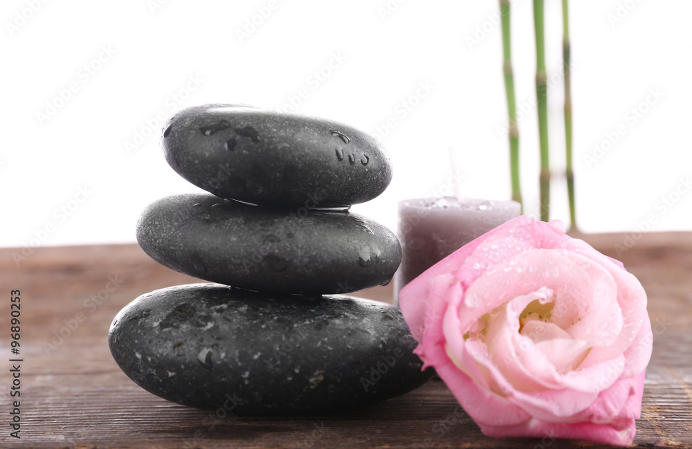 Spa stones, a candle and a rose, isolated on white