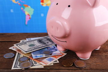 Poster - Piggy money box, banknotes and coins on wooden table, close-up