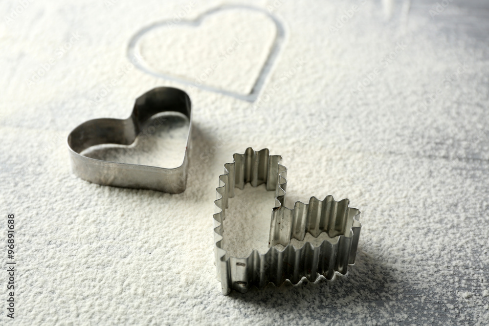 Heart of flour on wooden background