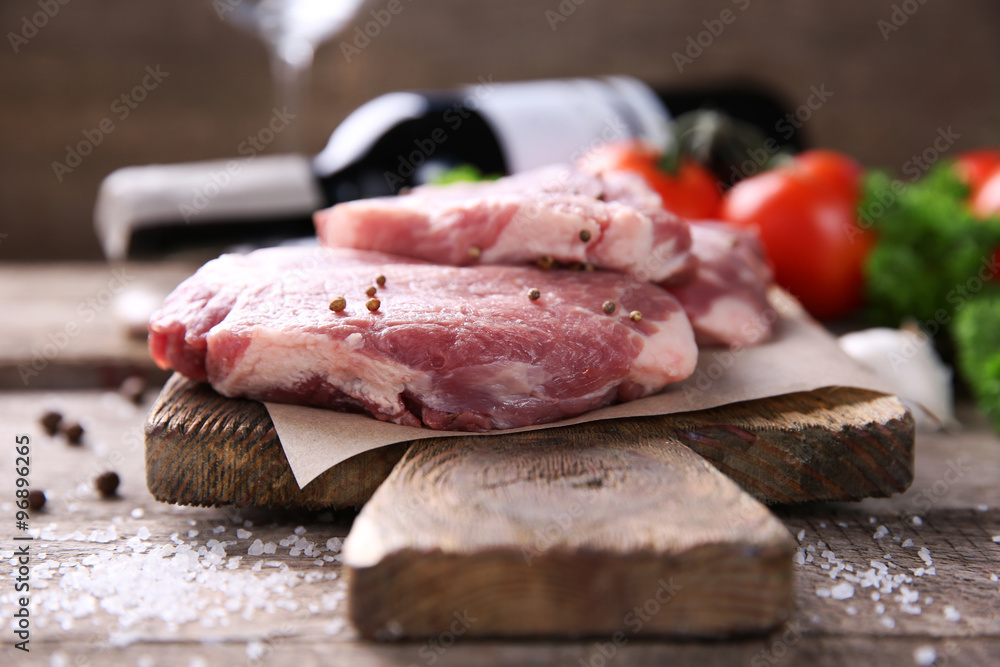 Marbled beef steak and spices on wooden background