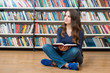 © ImageFlow - smiling young girl  sitting on the floor in the library with an