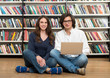© ImageFlow - smiling young girl and young man sitting on the floor in the lib