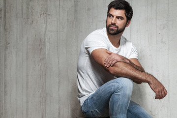 Portrait of an adult male in jeans in the interior of the loft