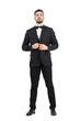Young bearded wealthy man buttoning tuxedo with bow tie. Full body length portrait isolated over white studio background.