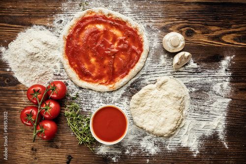 Pizza dough with ingredients on wood Canvas Print