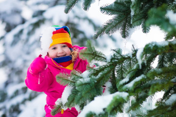 Wall Mural - Little girl with icicle in snowy winter park