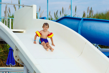 little boy having fun on waterslide pool