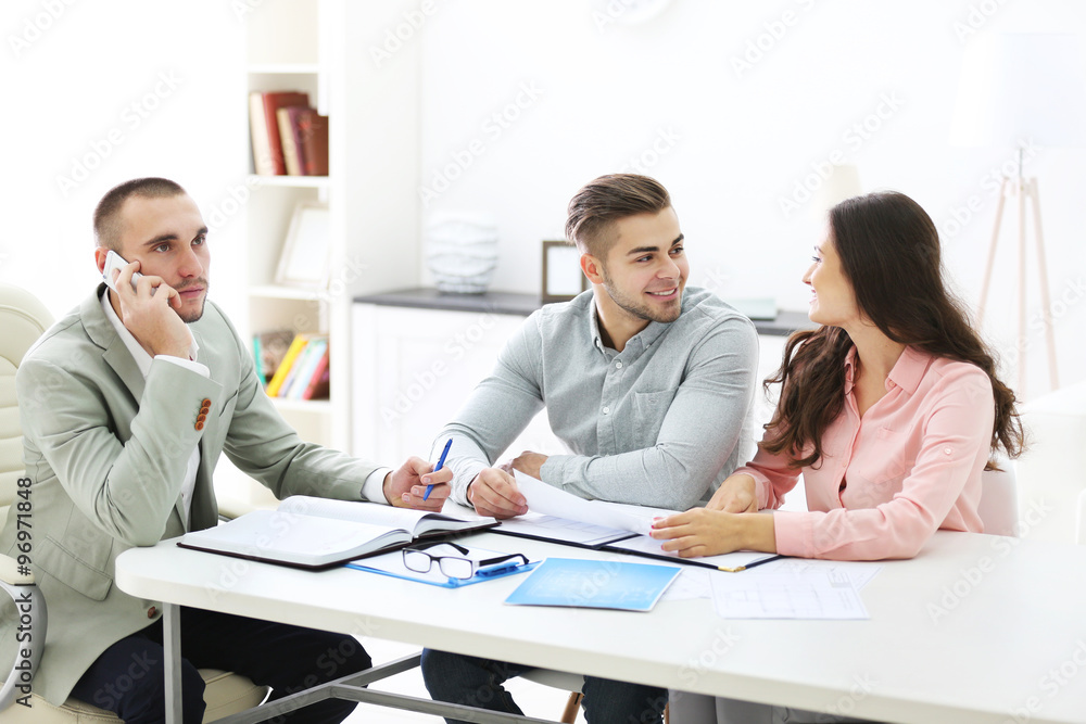 Happy family with estate agent,  in bright office