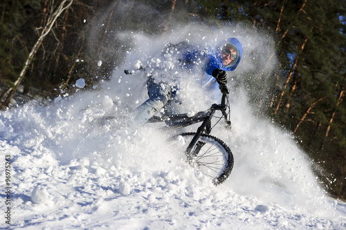 Extreme Cyclist Riding Mountain Bike In Flying Snow Near Winter Forest