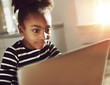 © Flamingo Images - Trendy little girl using a laptop at home