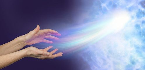 Peace at last - female hands on a darkness to light background and a soul energy formation moving out towards the light depicting soul release