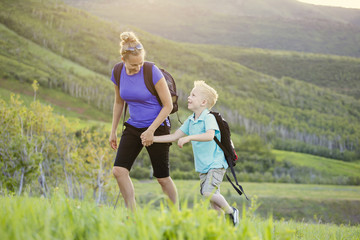 family hiking in the mountains. a young mother and her son take a hike together in the mountains on 
