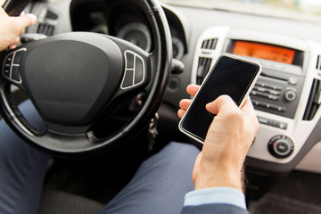 Poster - close up of man hand with smartphone driving car