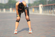 © lzf - tired woman runner taking a rest after running hard on sunshine seaside