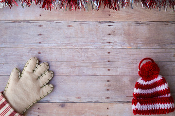 hat and mittens ornaments on a wood background.