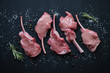 Top view of raw bobby veal rack steaks on a black wooden surface