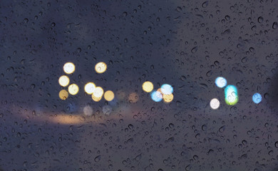 Wall Mural - Soft romantic colour bokeh light background with water or rain drop on mirror glass plate window