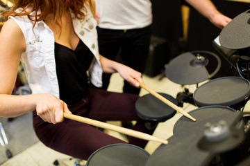 close up of man and woman playing on drum kit