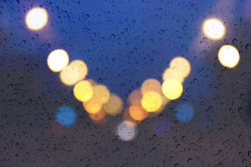 Wall Mural - Soft romantic colour bokeh light background with water or rain drop on mirror glass plate window