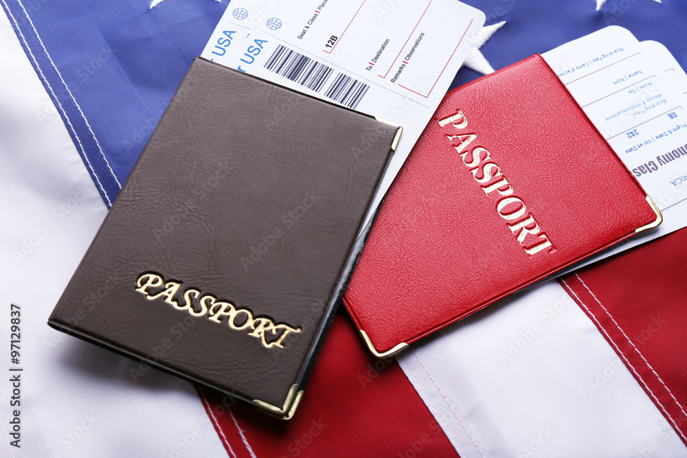 Passports, tickets lying on American Flag background