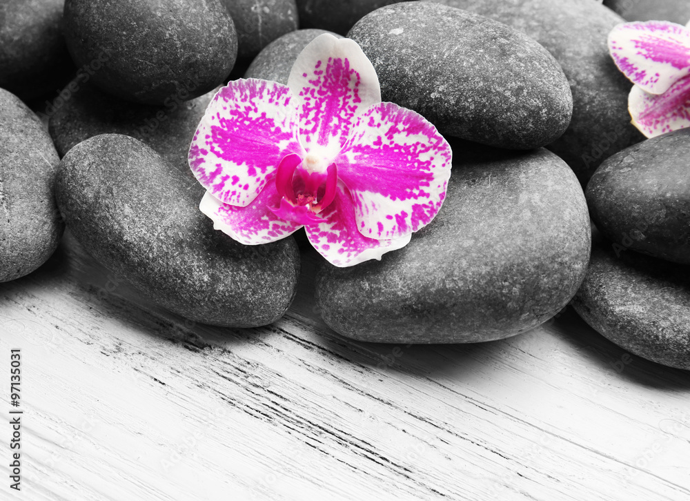Spa stones and orchids on wooden background