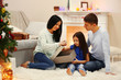 © Africa Studio - Happy family on the floor with gifts in the decorated Christmas room