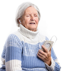 Wall Mural - Senior woman listening to music and singing over white background