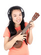 © nungning20 - Happy asian woman is  playing ukulele and listening the music with smile on white background