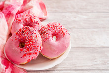 
Sweet Donuts With Strawberry And Cherry Pink Icing And Milk On A Wooden Background