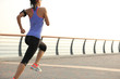 © lzf - young woman runner athlete running at seaside