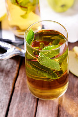 Canvas Print - Glasses of apple juice with fruits and fresh mint on table close up