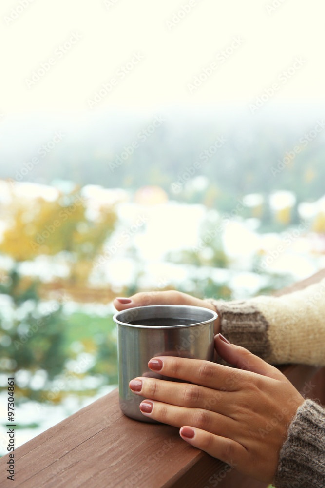 Hand holding coffee cup on mountains background