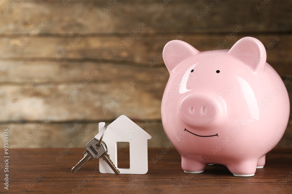 Pig money box and paper decor on wooden wall background