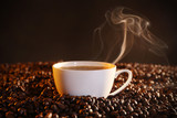 Fototapeta  - Cup of hot coffee and coffee beans closeup