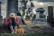Lonely Sad Young Woman In Mourning In Front Of A Gravestone