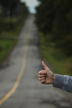 Closeup Of A Thumbs Up Of A Caucasian Woman Hitchhiking