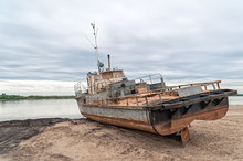 Old Rusty Ship On Sand Beach Against River Panorama At Dawn. Solvychegodsk, Arkhangelsky Region, Russia.
