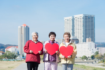 Wall Mural - 赤いハートマークを持って立っている3人の日本人高齢者