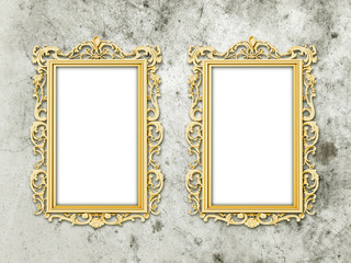 Two golden baroque frames on old grey scratched concrete wall background