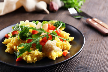 Sticker - Black plate with vegetable risotto on served wooden table