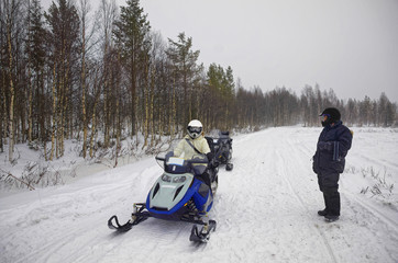 Wall Mural - Woman driving snowmobile in Ruka in Lapland