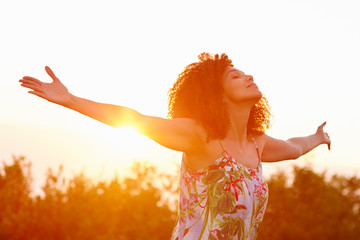 woman outstretched arms in an expression of freedom with sunflar