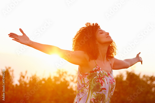 Photographie Woman outstretched arms in an expression of freedom with sunflar
